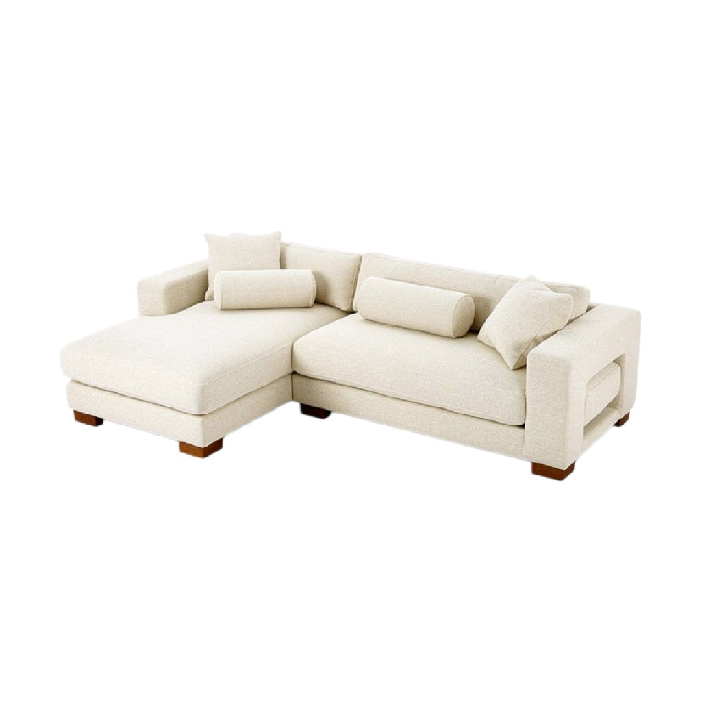 L-vormige beige bank met kussens en houten poten